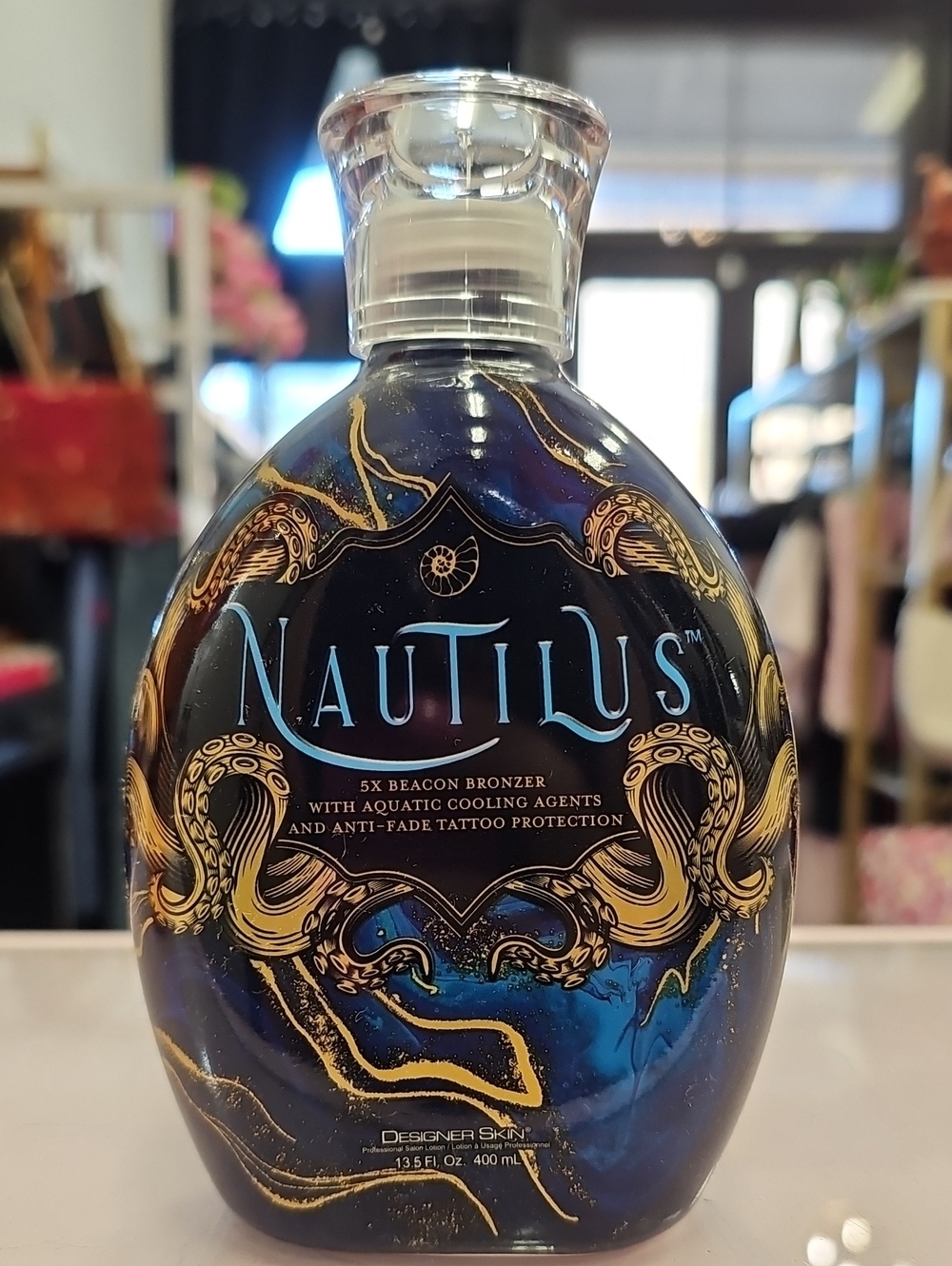 Nautilus Tanning Bronzing Lotion in Deep Blue & Gold Accents. Designer Skin